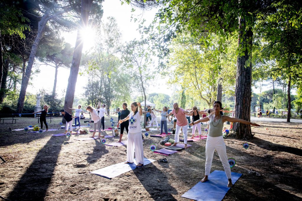 People doing yoga in the park in the morning